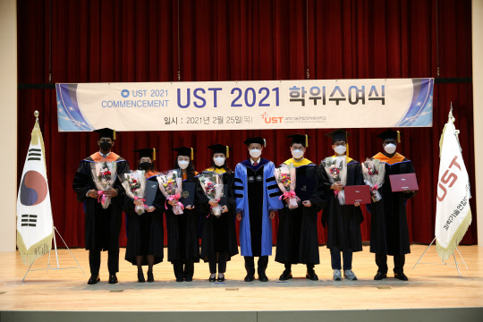 25일 대전 UST 본부에서 열린 '2021년 학위수여식'에서 김이환 UST 총장(왼쪽 다섯번째)이 우수한 연구성과를 거둔 졸업생들과 기념촬영을 하고 있다.  UST 제공